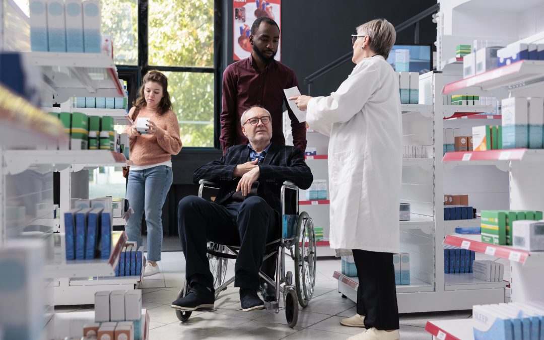 pharmacien aidant un client avec un fauteuil roulant